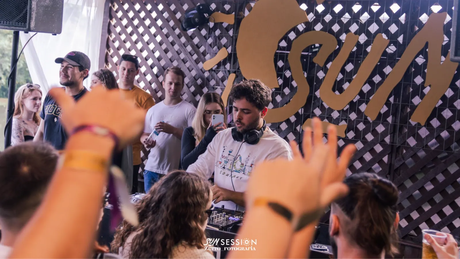 William Kaiser tocando ao vivo no Sun Session, de fone, com o público de mãos levantadas